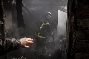 Fire fighters battle to put out a fire at the home of Vladimir Okremenko and his sister Svetlana Ilyuhina, after it was struck in a Russian multiple rocket attack in the Nyvky district of western Kyiv...