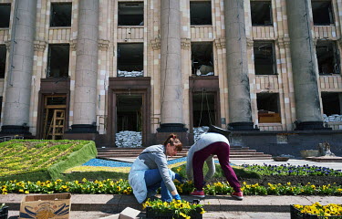 Women planting flowers in front of the Kharkiv Regional State Administration, a five-story building partially destroyed by Russian force's shelling on 1 March 2022 when 29 people were killed.