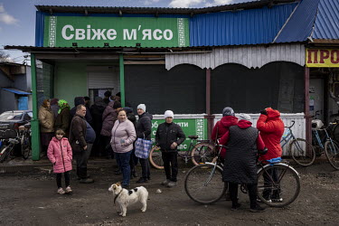 Locals in the recently liberated village of Nova Basan queue outside a butcher's shop, after fresh meat had reached the area for the first time in more than a month since the start of the war.