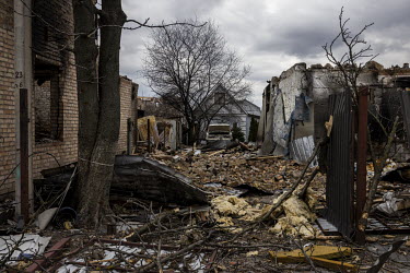 A car sits among rubble in a driveway in a heavily destroyed area in Bucha.