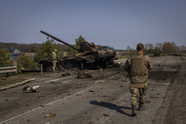 Deputy Battalion Commander Sulim and a fellow soldier, of the Ukrainian Armed Forces, examine a destroyed Russian T72 tank, at a frontline position in the northern region of Kyiv.