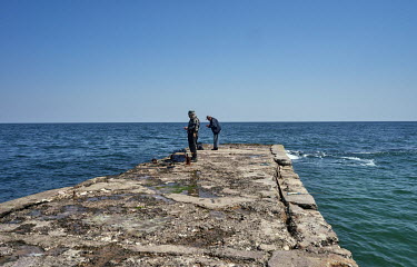Men fishing in Black Sea despite Russia's war.