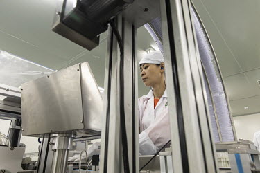 An employee wearing protective clothing operates on the production line at Guangzhou Pharmaceutical Holdings Ltd.'s Baiyunshan plant.