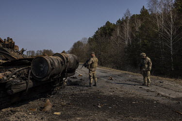 Deputy Battalion Commander Sulim and a fellow soldier, of the Ukrainian Armed Forces, examine a destroyed Russian T72 tank, at a frontline position in the northern region of Kyiv.