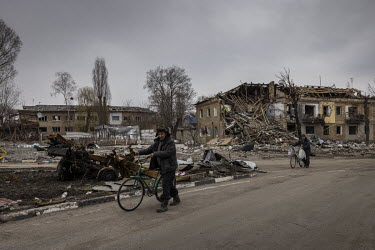 A man pushes a bicycle through the centre of the small town of Borodianka where, according to the acting mayor, as many as 200 people are missing, presumed dead, still lying under the rubble left afte...
