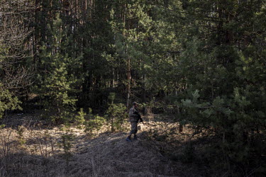 A Ukrainian soldier keeps watch near a forest at a frontline position in the northern region of Kyiv.