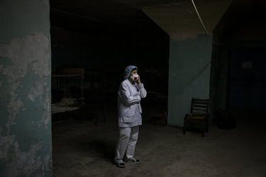 Natalya (62) who works as a caterer at a hospital in Kyiv, listens to the radio while taking shelter during an air raid siren, in the underground bunker at the hospital.