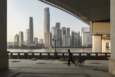 A labourer pulls a cart of sand under a bridge on the Peral River embankment in downtown Guangzhou.