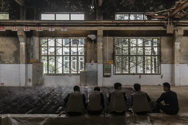 Employees rest after spreading out steamed sorghum to cool ahead of fermentation at the Kweichow Moutai Co. liquor factory in the town of Maotai in Renhuai. First favoured and promoted by former Chine...