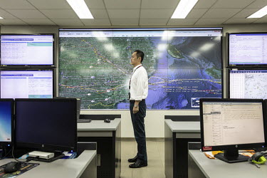 An employee stands in front of a screen displaying airline routes at a maintenance control centre of China Southern Airlines Co.
