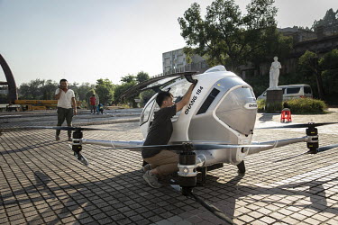 An employee checks an EHang Inc. E-184 drone ahead of a test flight at the testing facility at the EHang Inc. headquarters. The Chinese startup has developed a flying car that it plans to roll out as...