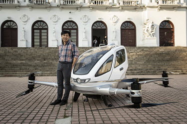 Hu Huazhi, founder and chief executive officer of EHang Inc., standing next to the company's E-184 drone at the EHang Inc. headquarters. The Chinese startup has developed a flying car that it plans to...