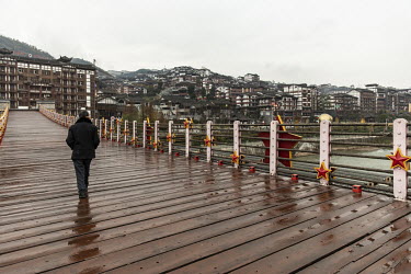 A man walks over a cable bridge in the town of Maotai in Renhuai.
