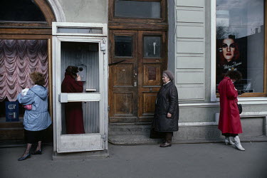 A woman makes a call from a public telephone booth outside a newly opened branch of luxury perfumier Lancome. Mikhail Gorbachev's Glasnost and Perestroika policies allowed western brands such as Lanco...