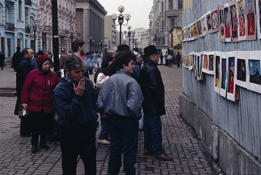 People looking at political cartoons by graphic artists displayed on Arbat Street.