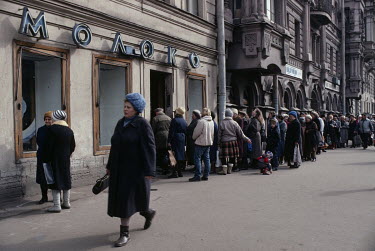 People queue to buy bread at a bakery.