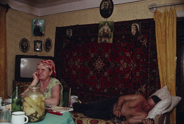 Vladimir, a coal miner, and his wife, who worked in the mine cafeteria for years, in the front room of their home where a portrait of Stalin hangs above various family portraits. Ukrainian coal miners...
