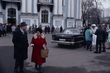 A wedding ceremony on Orthodox Easter Sunday at Saint Nicholas Naval Cathedral. The bride and groom stand besidwe a GAZ limousine.