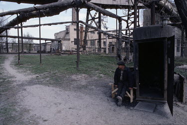 A man sits beneath a network of pipes at the Chaikina coal mine.
