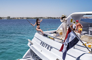 Tourists take pictures of each other on the the deck of a yacht in the sea off Hurgarda, a Red Sea resort popular with tourists from Russia and Eastern Europe.