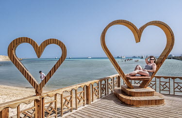 A tourist poses on a heart-shaped seat beside the beach in Hurgarda, a Red Sea resort popular with tourists from Russia and Eastern Europe.