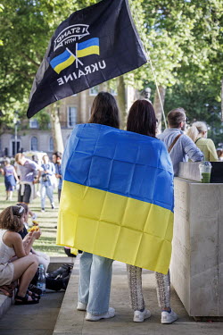 Women wrapped in a Ukrainian flag during a protest in Whitehall against the Russian invasion of Ukraine.