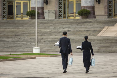 Attendants carry hot water flasks into the Great Hall of the People after the opening of the first session of the 13th National People's Congress (NPC).