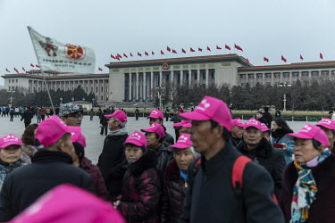 A tour group move through Tiananmen Square.