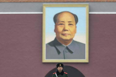 A soldier stands under a portrait of Chairman Mao on Tiananmen Square.