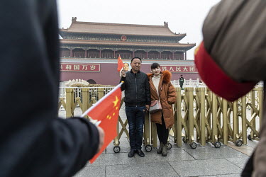Tourists pose for photographs in Tiananmen Square.