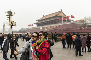 Tourists pose for a selfie photograph at Tiananmen Square in Beijing, China, on Sunday, March 4, 2018.