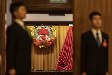 Attendants stand guard at an entrance leading into the auditorium of the Great Hall of the People ahead of the opening of the first session of the 13th Chinese People's Political Consultative Conferen...