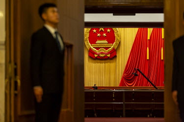 An attendant stands at the entrance of the auditorium at the Great Hall of the People before the opening of the first session of the 13th National People's Congress (NPC).