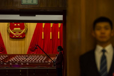 An attendant stands at the entrance of the auditorium at the Great Hall of the People before the opening of the first session of the 13th National People's Congress (NPC).