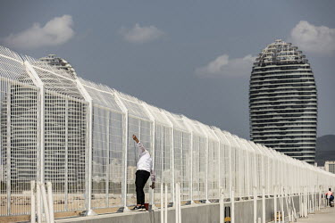 A worker paints a fence at the construction site for Phase II of Phoenix Island, an artificial archipelago developed by Sanya Phoenix Island Development Co.