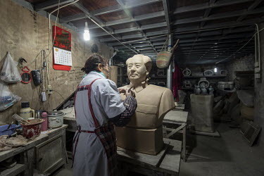 A worker sculpts a bust of former Chinese leader Mao Zedong inside a workshop at the Jingdezhen Porcelain Factory.
