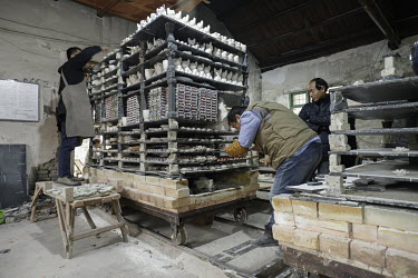 Staff prepare clay items for firing inside a workshop at the Jingdezhen Porcelain Factory.