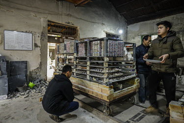 Staff prepare clay items for firing inside a workshop at the Jingdezhen Porcelain Factory.