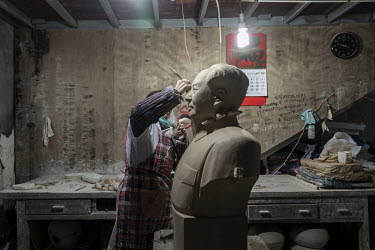 A worker sculpts a bust of former Chinese leader Mao Zedong inside a workshop at the Jingdezhen Porcelain Factory.