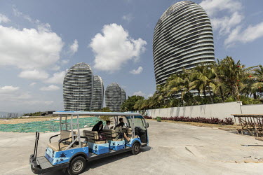 An electric vehicle transports people through the construction site for Phase II of Phoenix Island, an artificial archipelago developed by Sanya Phoenix Island Development Co.