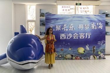 A tourist has her photo taken while waiting to take a cruise towards the disputed Spratley Islands in the South China Sea, at a terminal in Sanya.