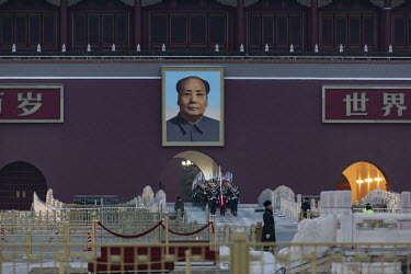 A portrait of Chairman Mao hangs above a team of honour guards walking through Tiananmen Square during the flag raising ceremony.