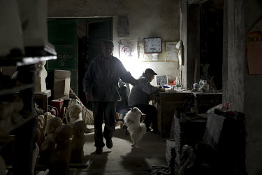 A pet dog greets a worker walking past busts of former Chinese leader Mao Zedong sit on a shelf inside a workshop at the Jingdezhen Porcelain Factory.