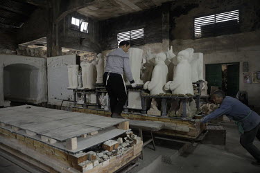 A worker pushes a cart loaded with busts of former Chinese leader Mao Zedong into a furnace for firing at a workshop at the Jingdezhen Porcelain Factory.