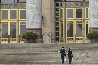 Attendants carry hot water flasks into the Great Hall of the People after the opening of the first session of the 13th National People's Congress (NPC).