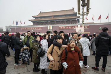 Tourists take selfies while standing on Tiananmen Square.