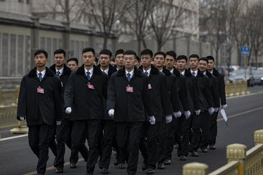 Security personnel march through the grounds of the Great Hall of the People.