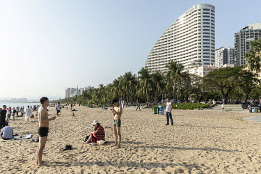 Tourists and residents play on a beach.