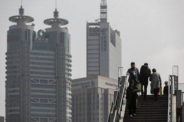 Visitors walk on a foot bridge in the Lujiazui Financial Center.