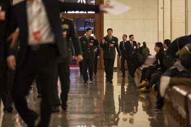 Military delegates walk through the 13th National People's Congress (NPC) at the Great Hall of the People.